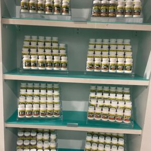 A shelf with a lot of Vitamin-Garlic Oil jars on it.