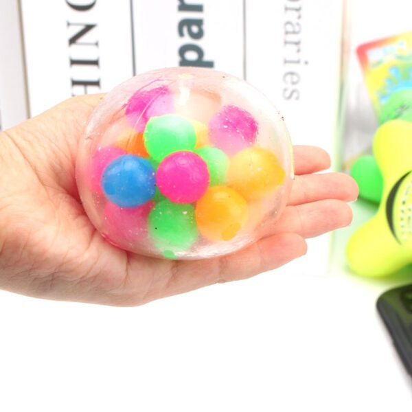 A person holding a Stress Ball Fidget Toy with colorful balls in it.