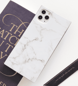A white marble iPhone case with a book on it.