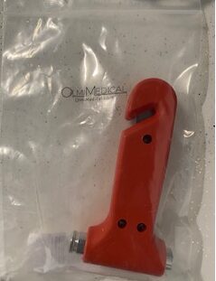 A red Emergency Tool Window Breaker in a plastic bag.