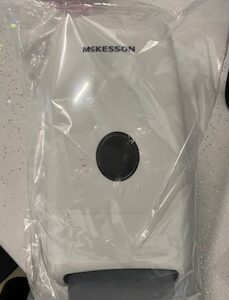 A white plastic bag with a McKesson Soap Dispenser in it.
